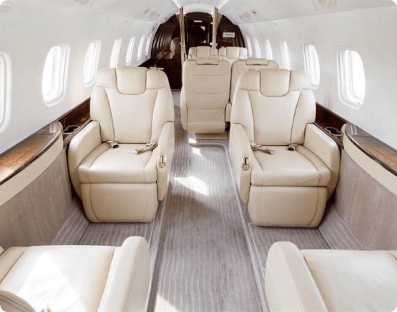 Luxury private jet interior with cream leather seats and modern amenities